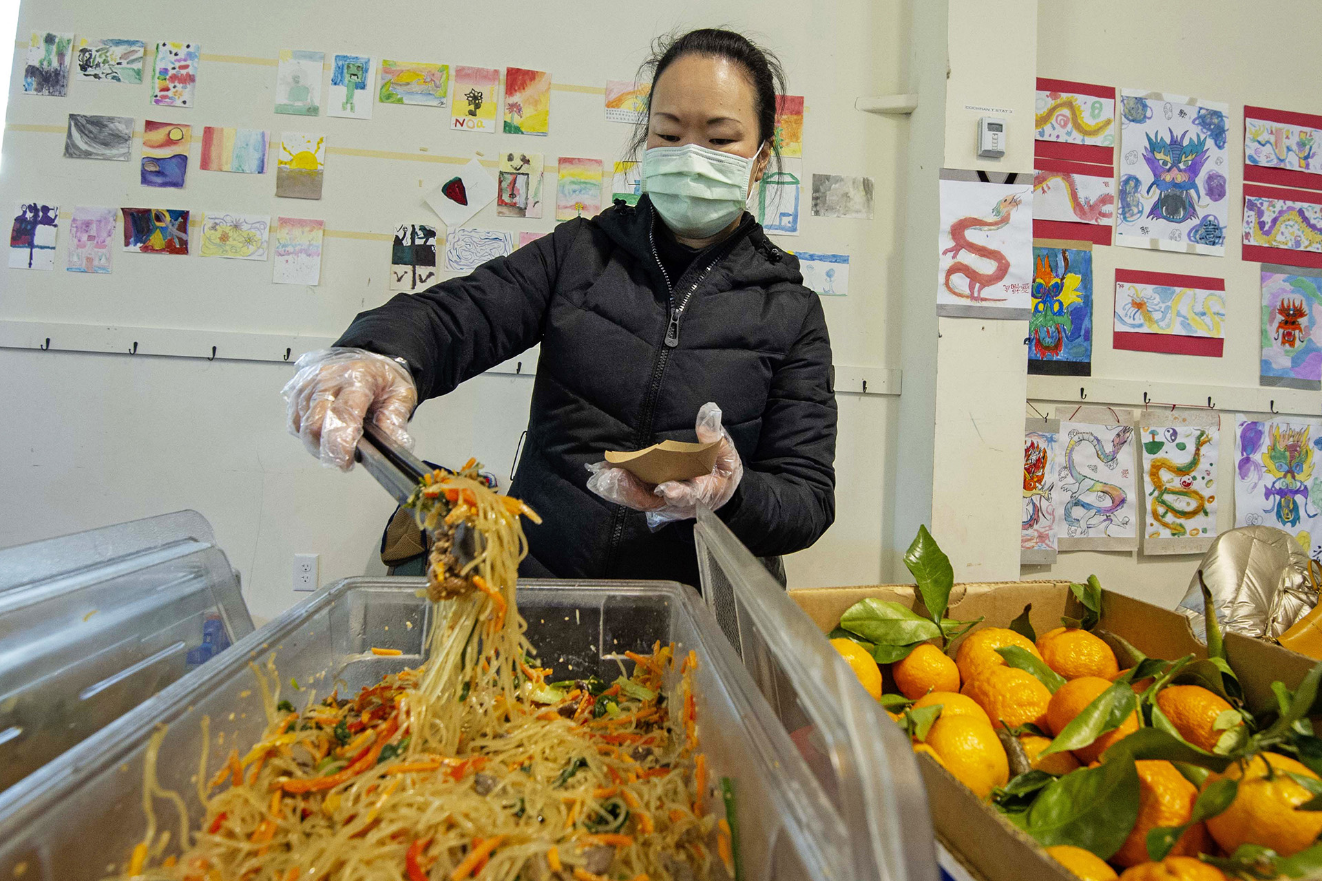 Amy Danos serves Korean japchae donated by Salaryman restaurant during the Lunar New Year Celebration at Legacy Park in Decatur on Saturday, Jan. 29. 2022. Photo by Dean Hesse.