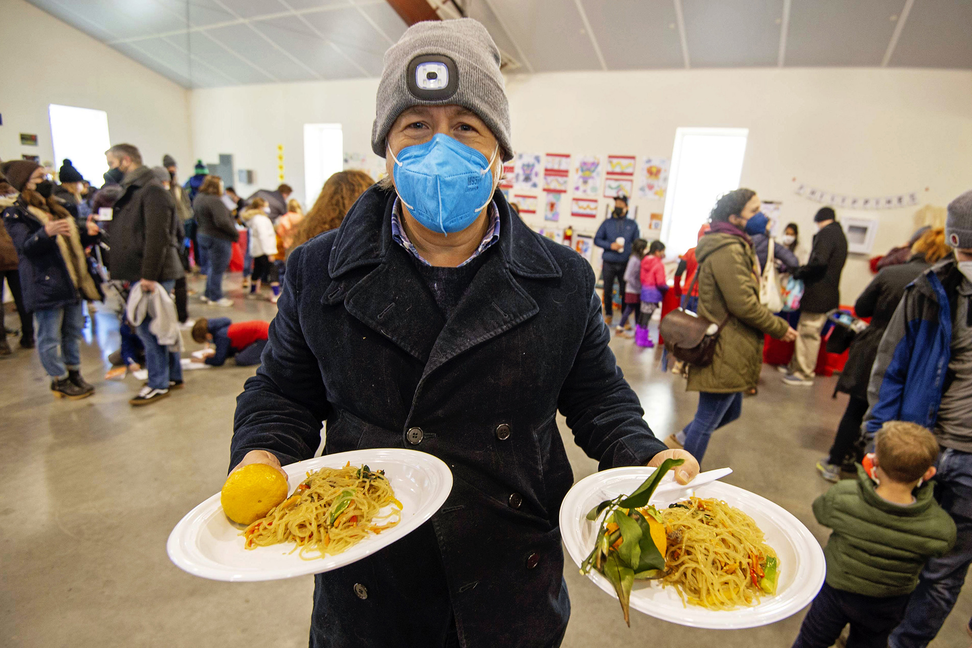Randolph Kallenberg holds plates of Korean japchae and mandarin oranges during the Lunar New Year Celebration at Legacy Park in Decatur on Saturday, Jan. 29. 2022. Photo by Dean Hesse.